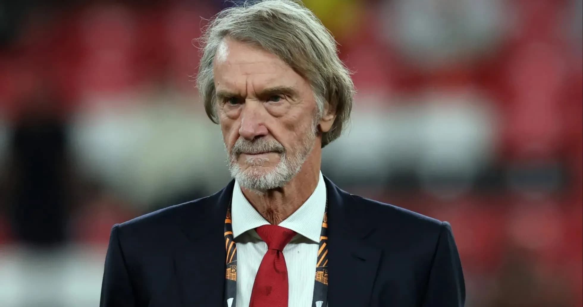Man in suit with a red tie at stadium