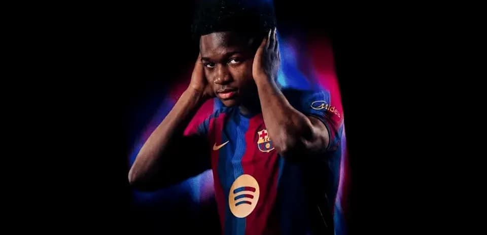 Player in Barcelona jersey posing with hands on ears