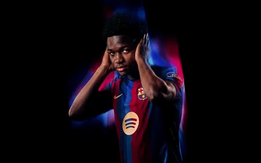 Player in Barcelona jersey posing with hands on ears