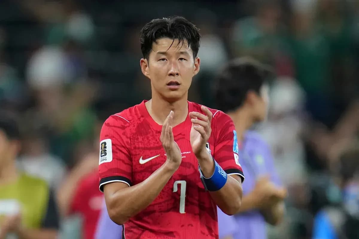 Player applauding fans after match in red jersey