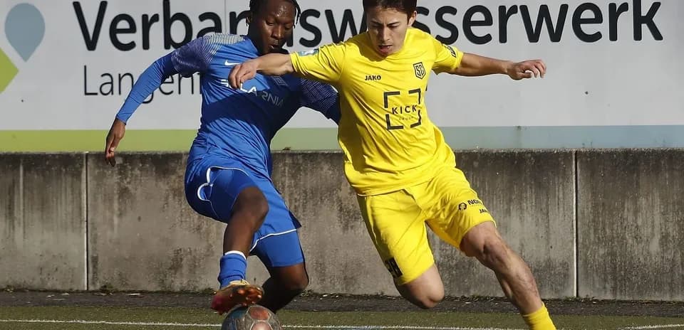 Players competing for the ball in football match