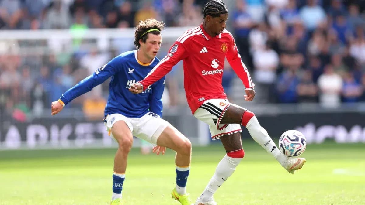 Manchester United player dribbling past Everton opponent Manchester United player dribbling past Everton opponent