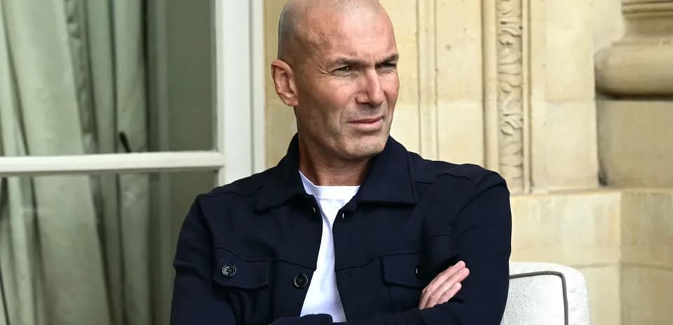 Man seated with arms crossed, outdoor setting