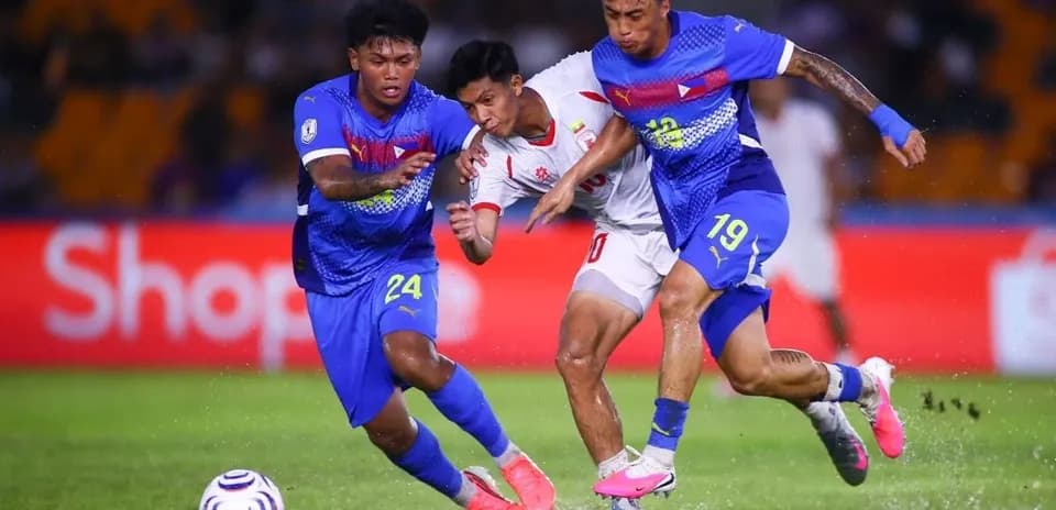 Two players tackling opponent during football match