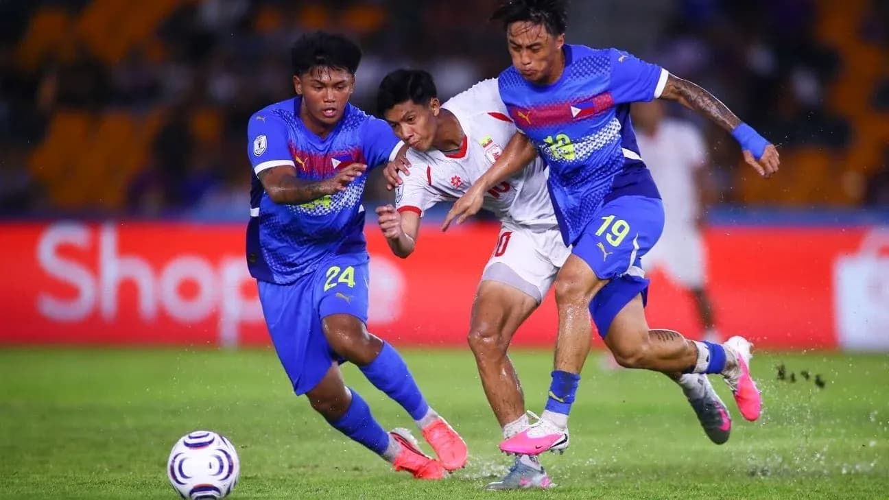 Two players tackling opponent during football match