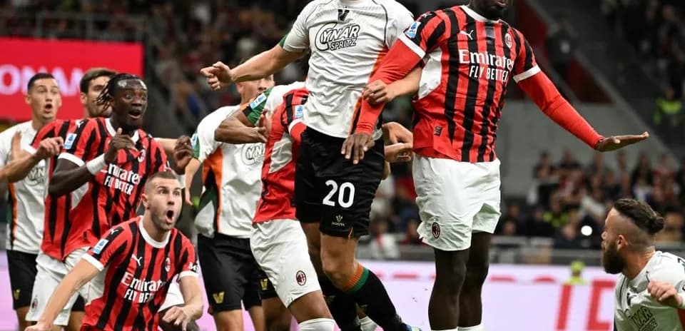 Players contesting a header during AC Milan match