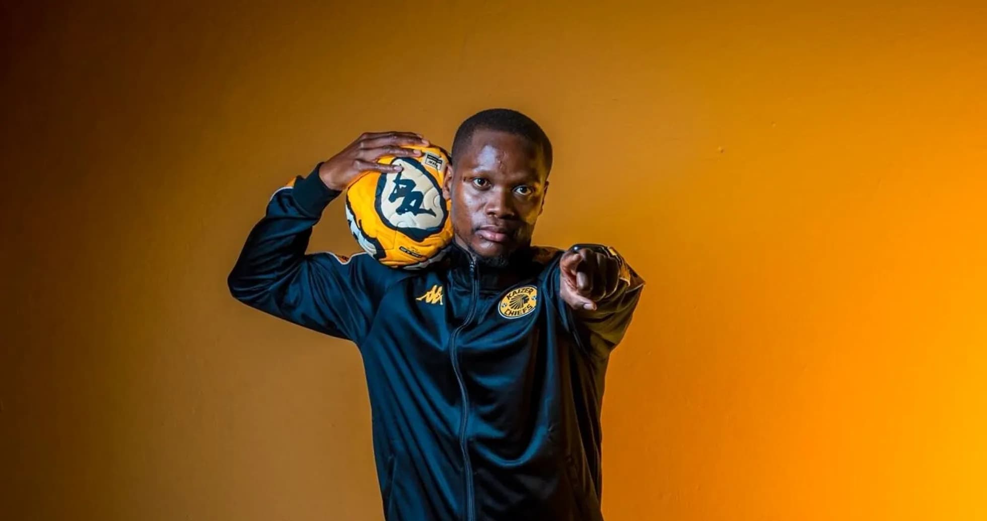 Player holding soccer ball and pointing confidently