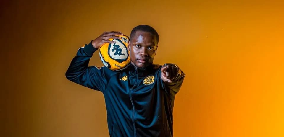Player holding soccer ball and pointing confidently