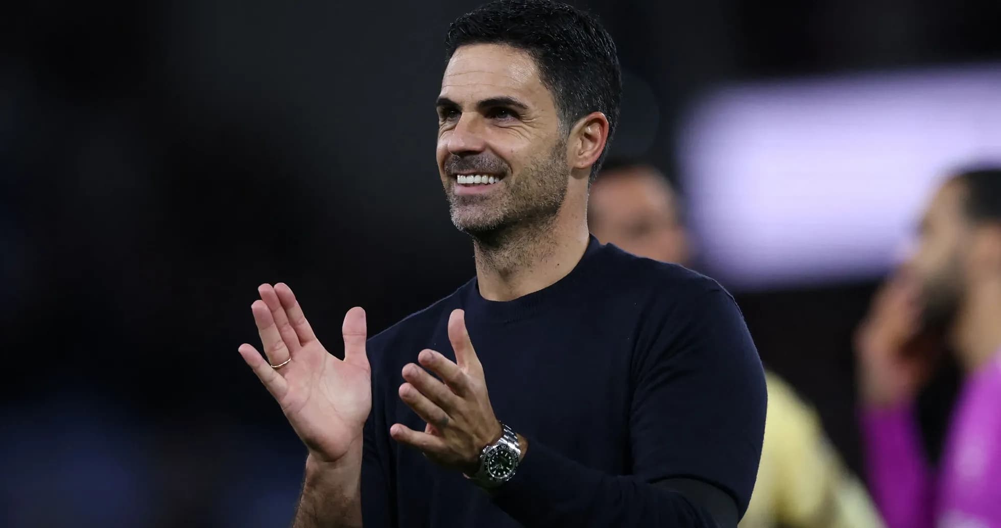 Coach clapping and smiling during match