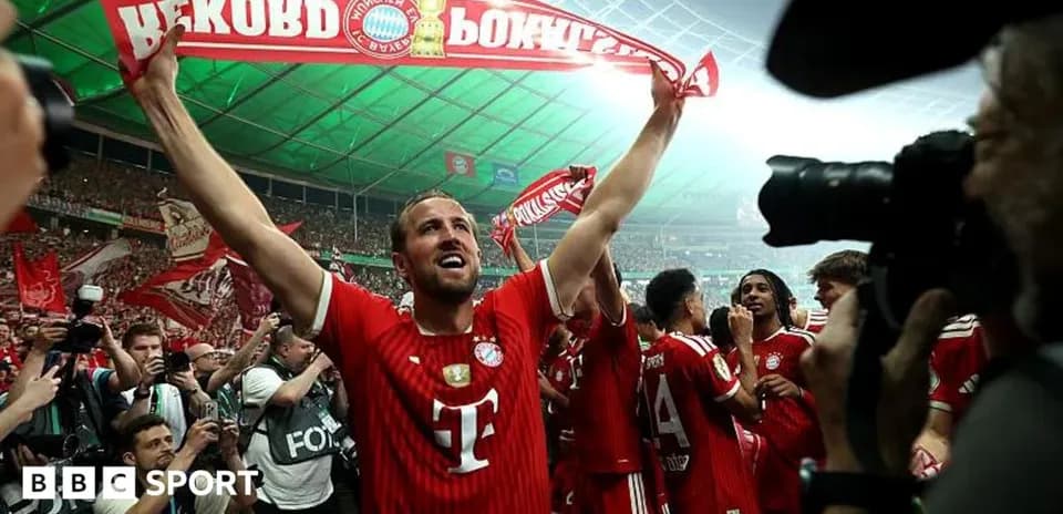 Player celebrating with fans holding a banner