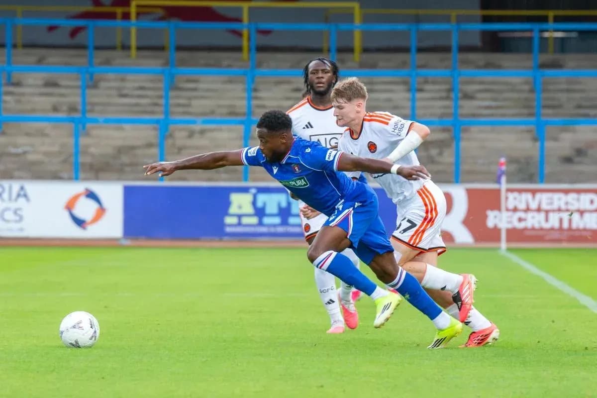 Player in blue shirt attempting to evade two defenders