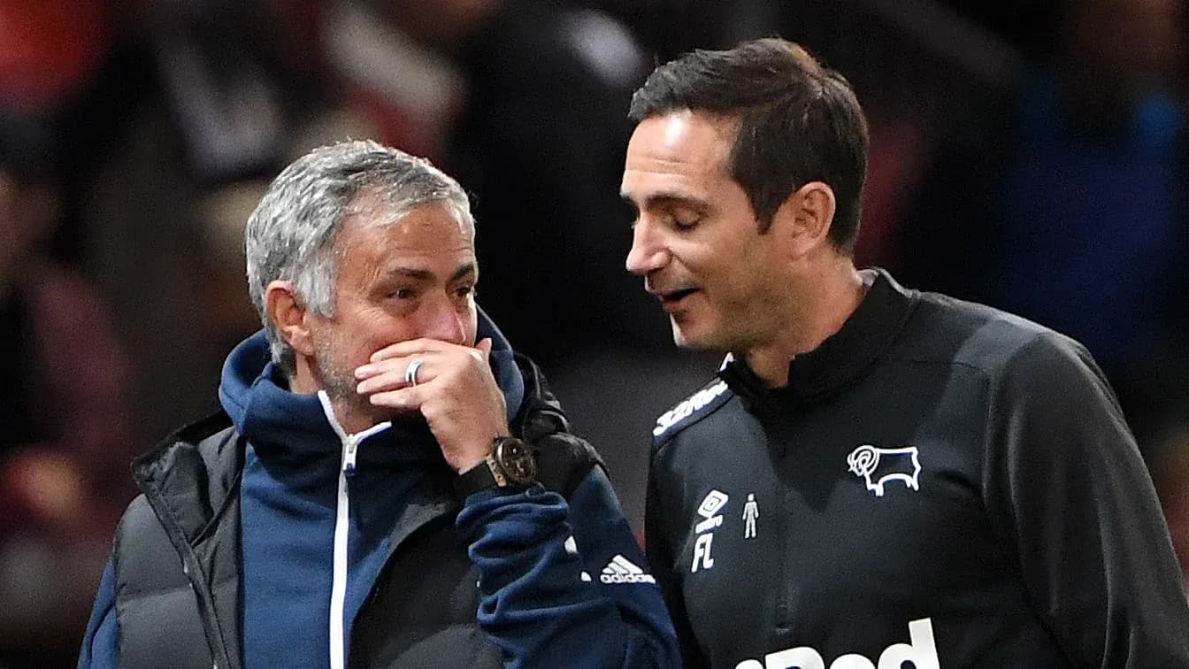 Two football managers conversing on the sidelines