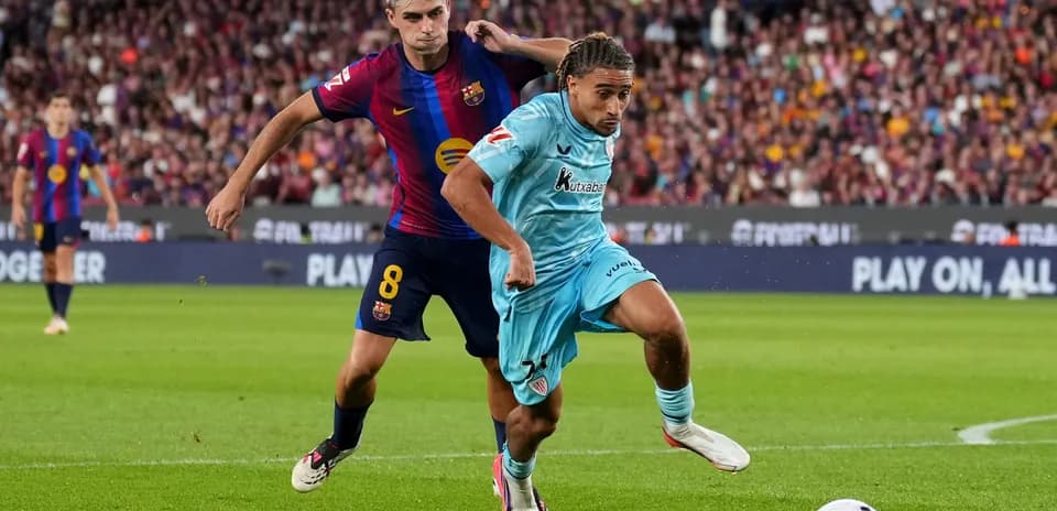 Barcelona player tackling opponent during match