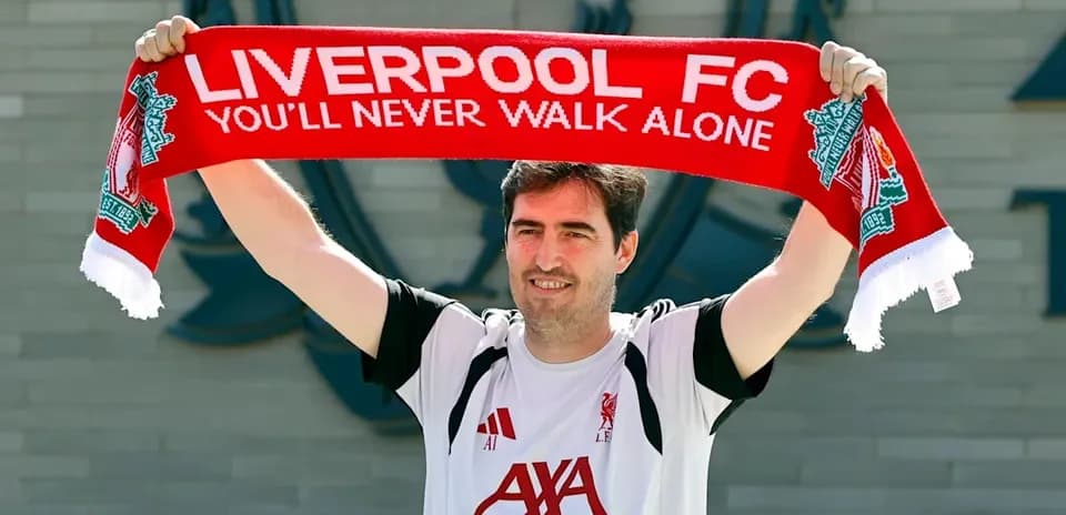 Man holding Liverpool FC scarf outside club building