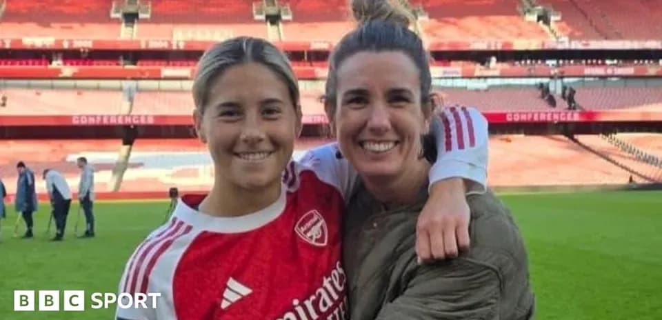Two women posing together on football pitch