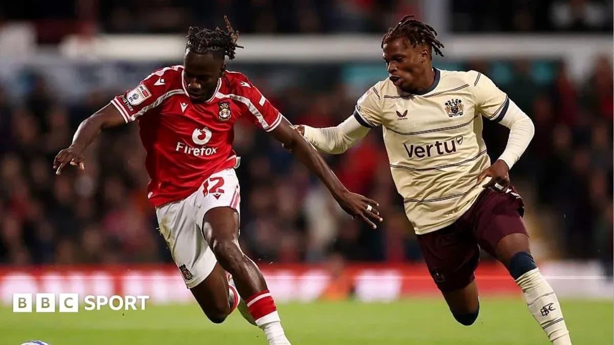 Player in red jersey dribbling past opponent in beige jersey