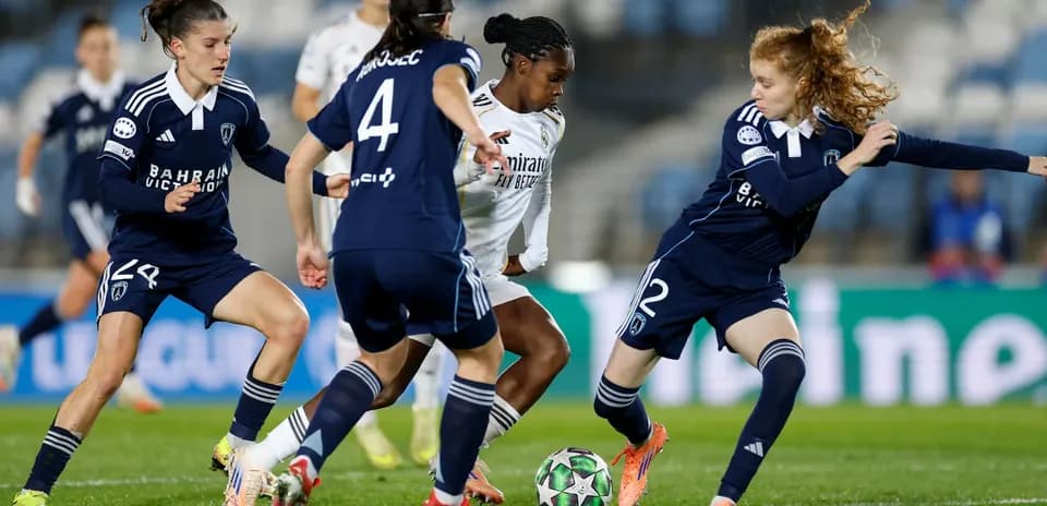 Real Madrid player dribbling past Paris FC defenders