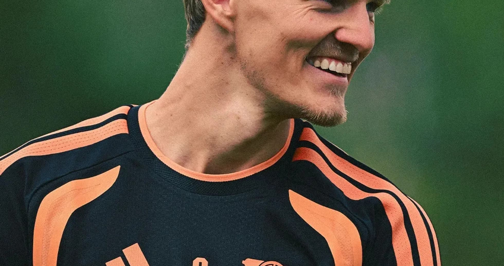 Player smiling during training session in Arsenal kit