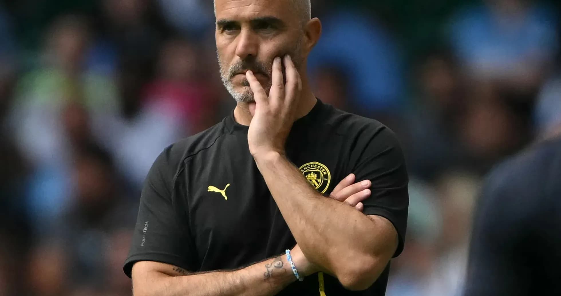 Manager observing the game with hand on chin