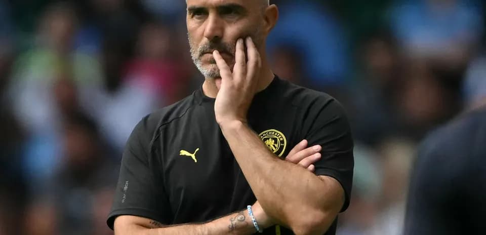 Manager observing the game with hand on chin