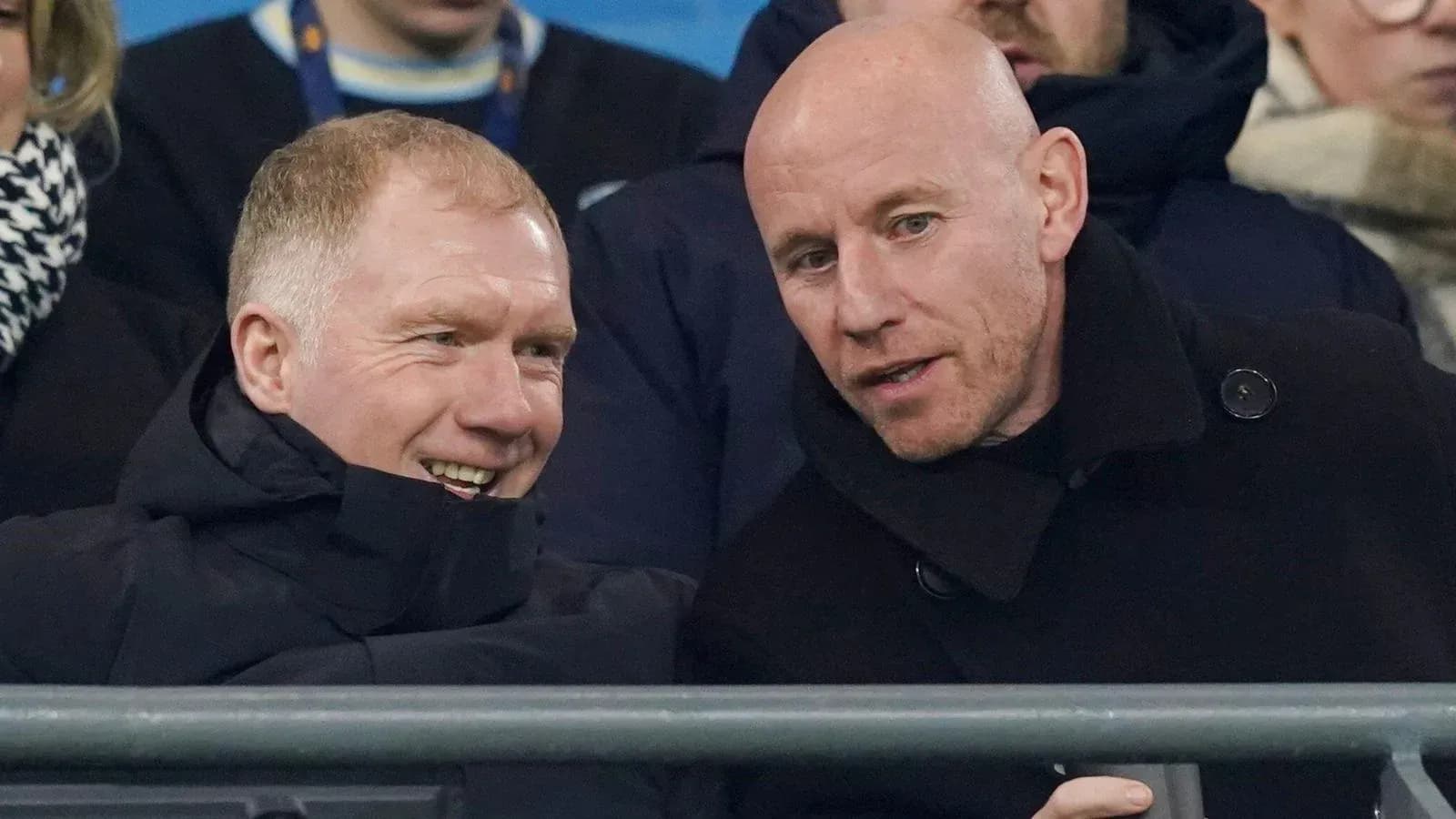 Two men chatting in stadium seats during match