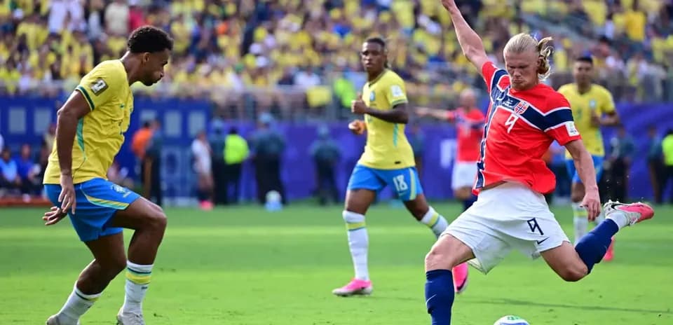 Brazil player attempting to tackle Norwegian forward