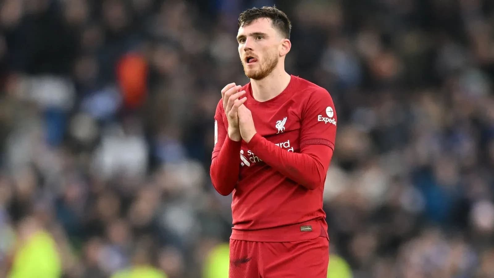 Player in red Liverpool kit applauding fans