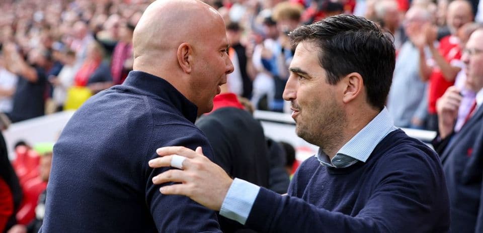 Two coaches greeting each other before a match