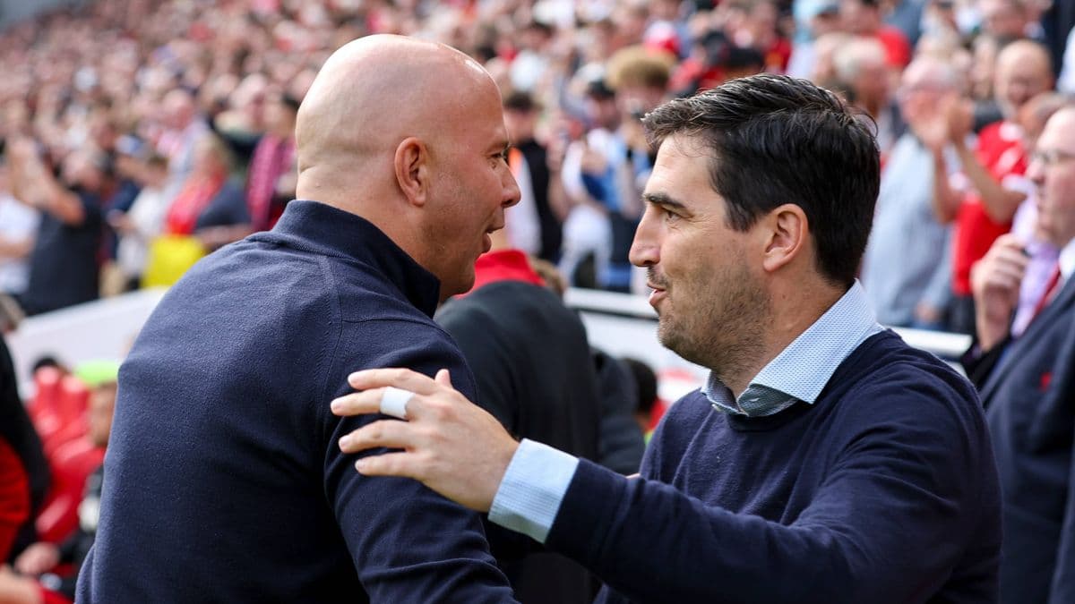 Two coaches greeting each other before a match