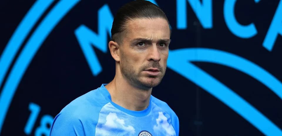 Player in Manchester City kit at stadium entrance