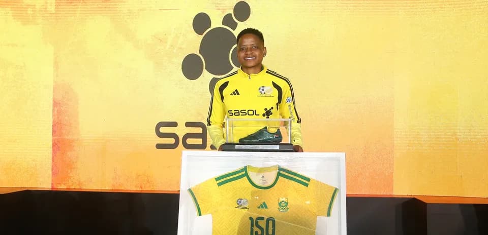 Player posing with jersey and soccer boots at event