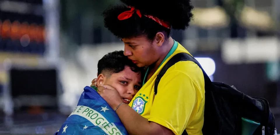 Two fans embracing with Brazilian flag during event