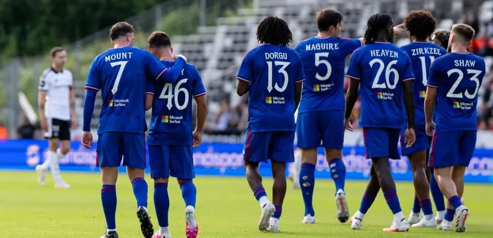 Players in blue jerseys celebrating on the field