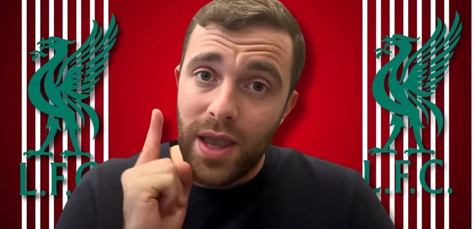 Person gesturing with finger in front of Liverpool logo
