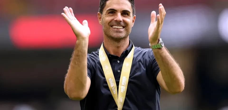 Coach clapping with a medal around his neck