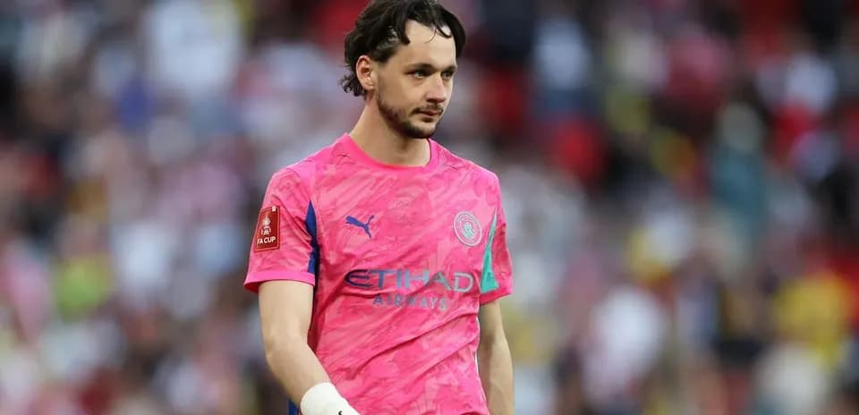 Goalkeeper in pink jersey walking on the pitch