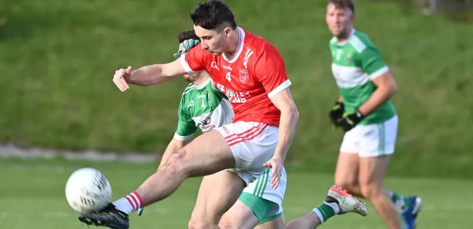 Player in red kicking ball during Gaelic football match