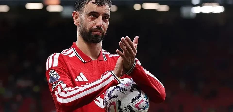 Player applauding fans while holding a ball