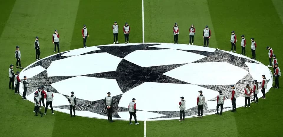 Ground staff preparing Champions League logo on pitch