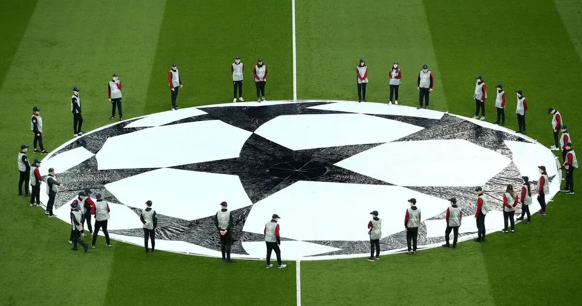 Ground staff preparing Champions League logo on pitch Ground staff preparing Champions League logo on pitch
