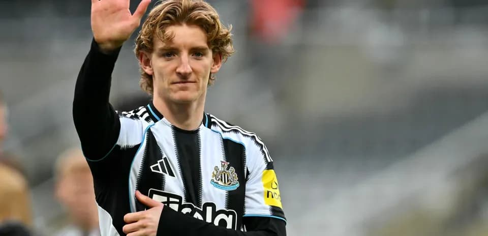 Player waving while wearing Newcastle United jersey