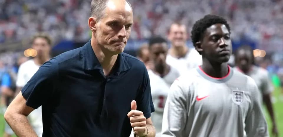 Manager walking off field with players behind