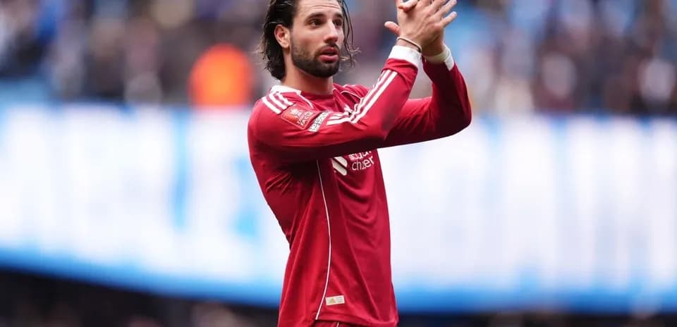 Player applauding fans during match in red jersey