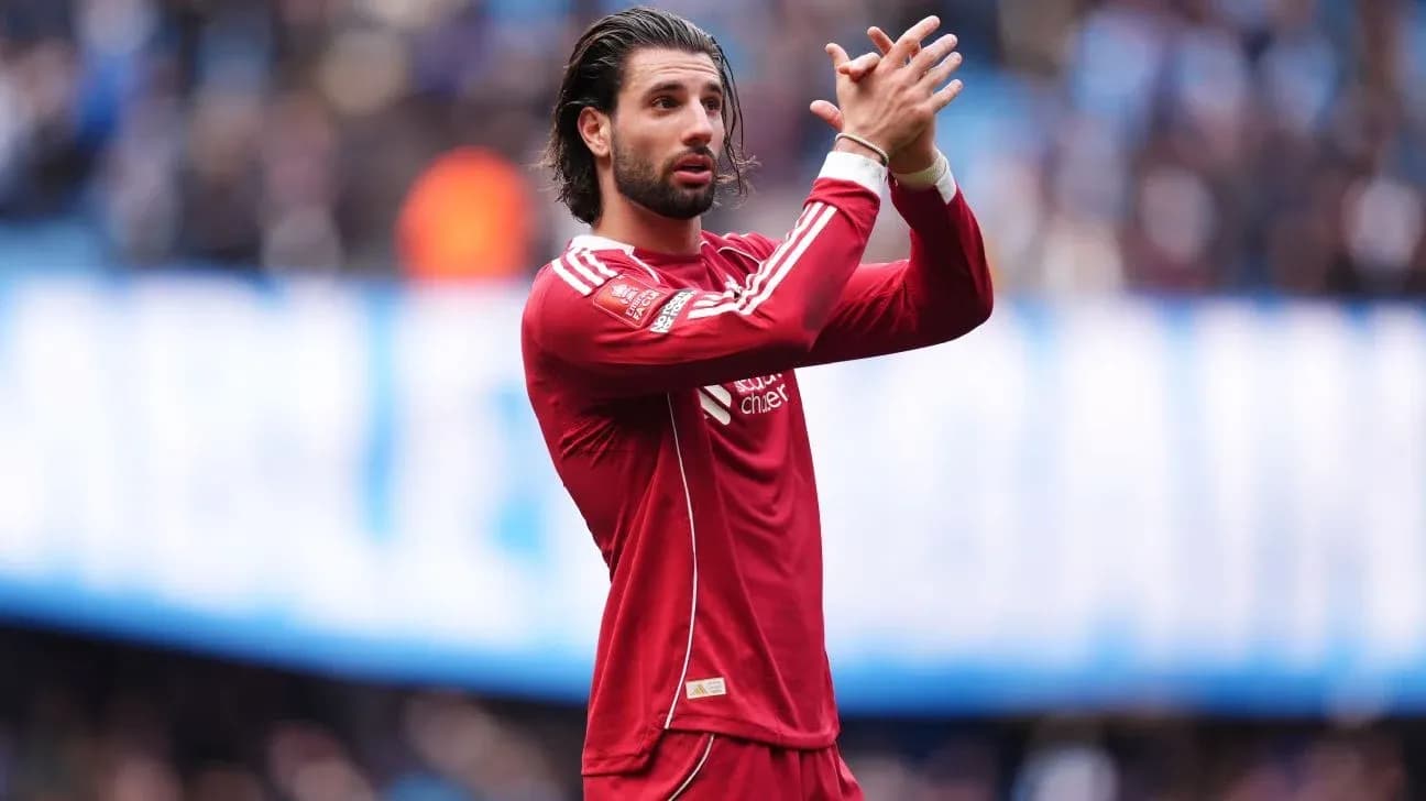 Player applauding fans during match in red jersey
