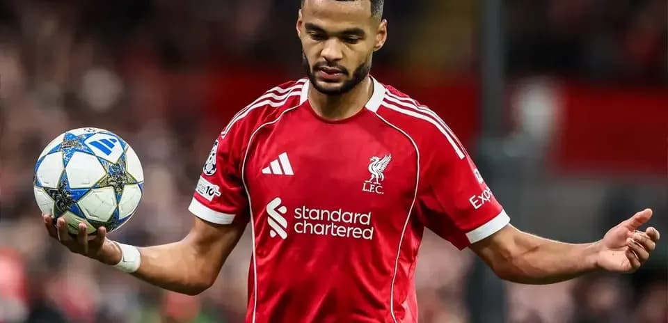 Player in red Liverpool jersey holding a soccer ball