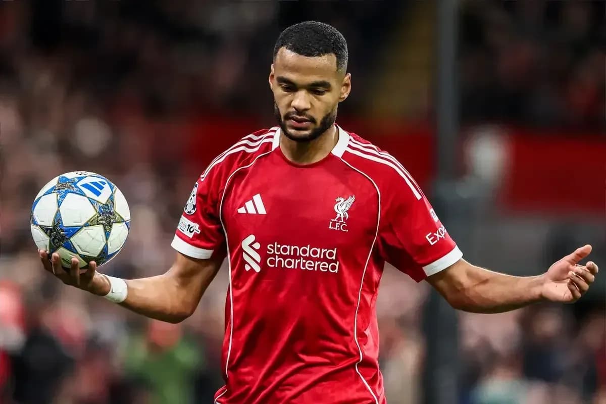 Player in red Liverpool jersey holding a soccer ball