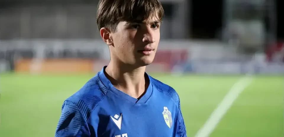 Player in blue jersey standing on football field