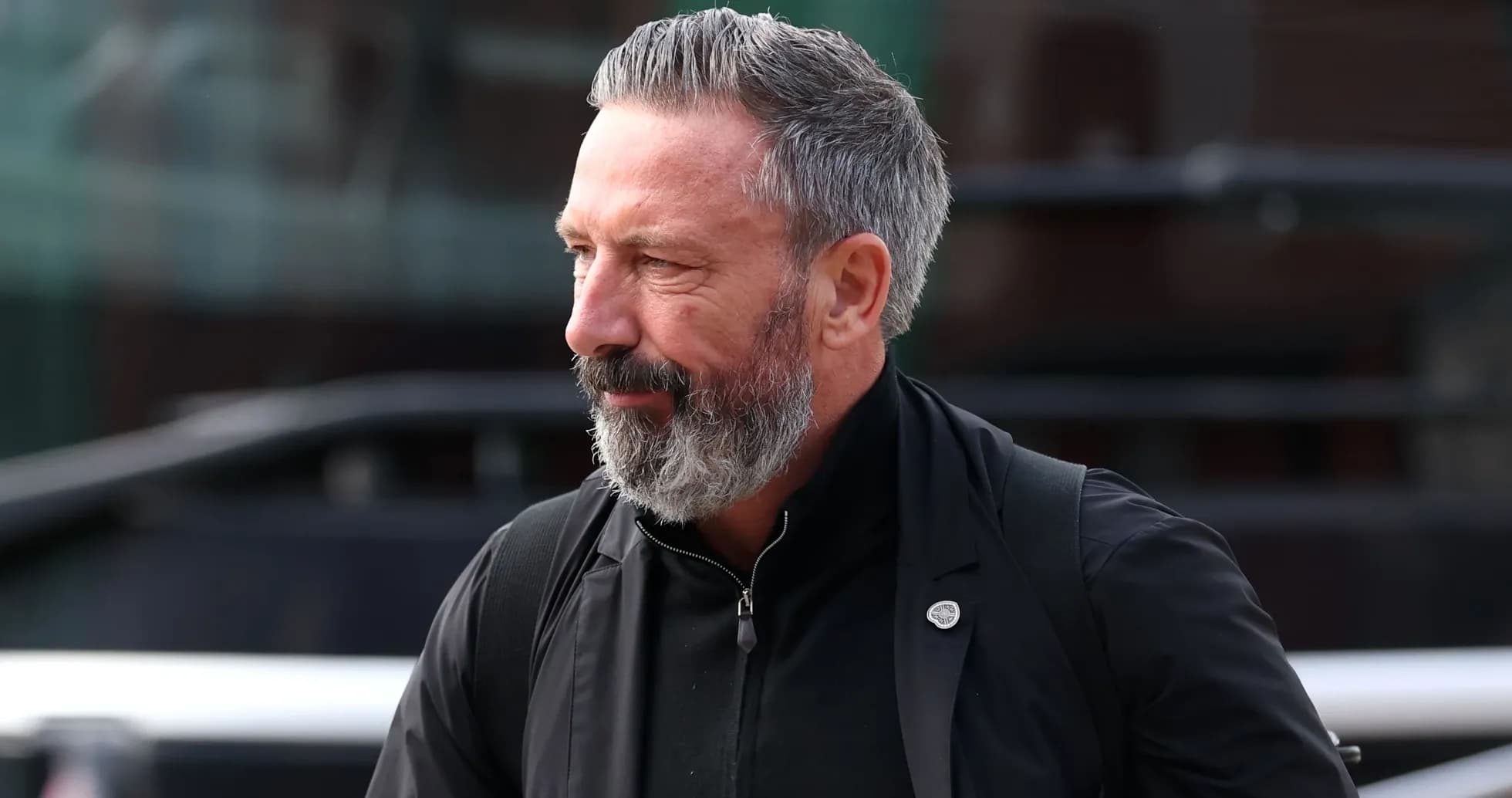 Man with beard walking outside a vehicle
