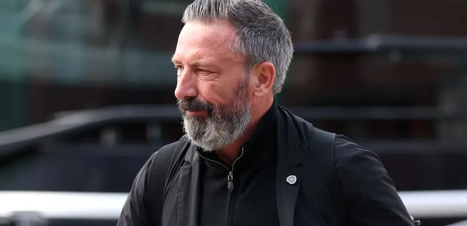 Man with beard walking outside a vehicle