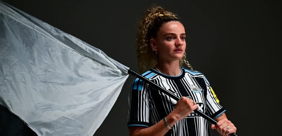 Player holding a flag wearing Newcastle kit